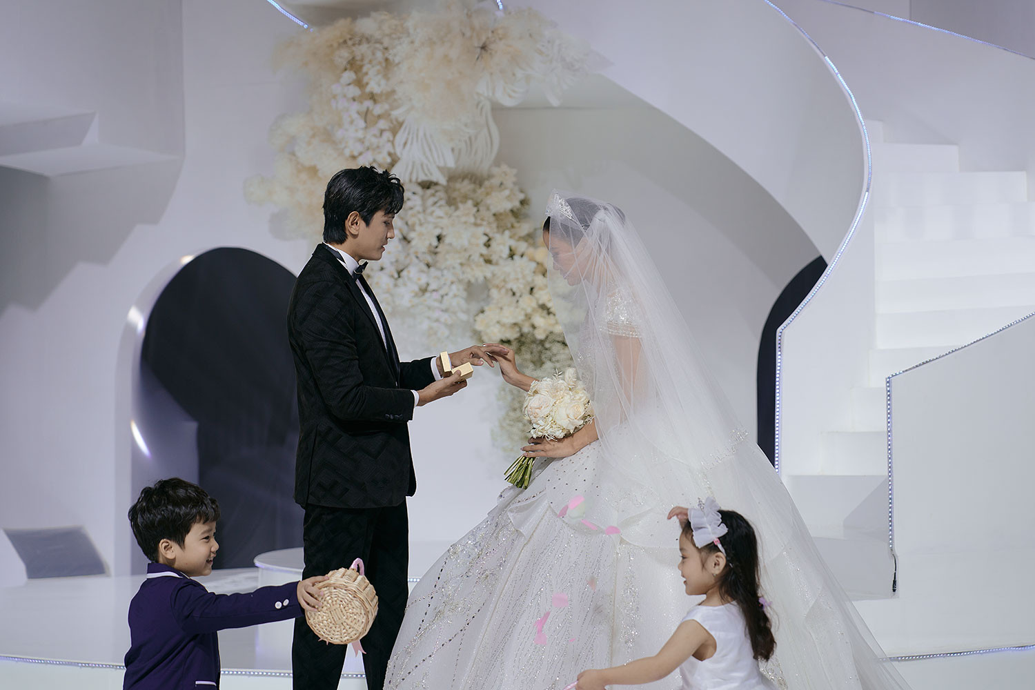 Á hậu Hương Ly cùng bạn diễn thực hiện nghi thức trao nhẫn cưới, và tung hoa cho các bạn diễn. 