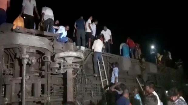 Những đoàn cứu hộ trèo lên một trong những đoàn tàu bị lật để tìm kiếm người sống sót (Ảnh: Reuters)