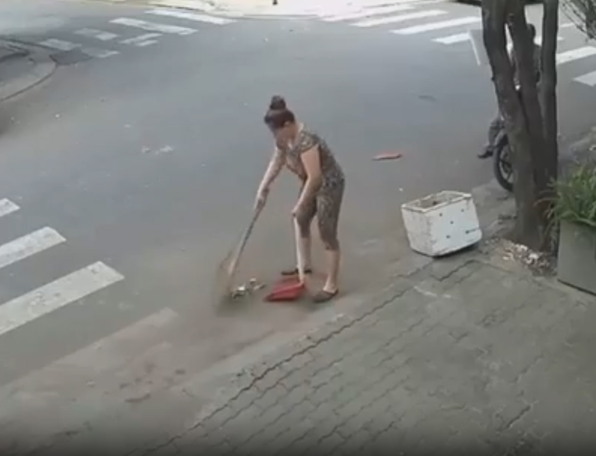 Người phụ nữ đang quét rác ngay trước nhà