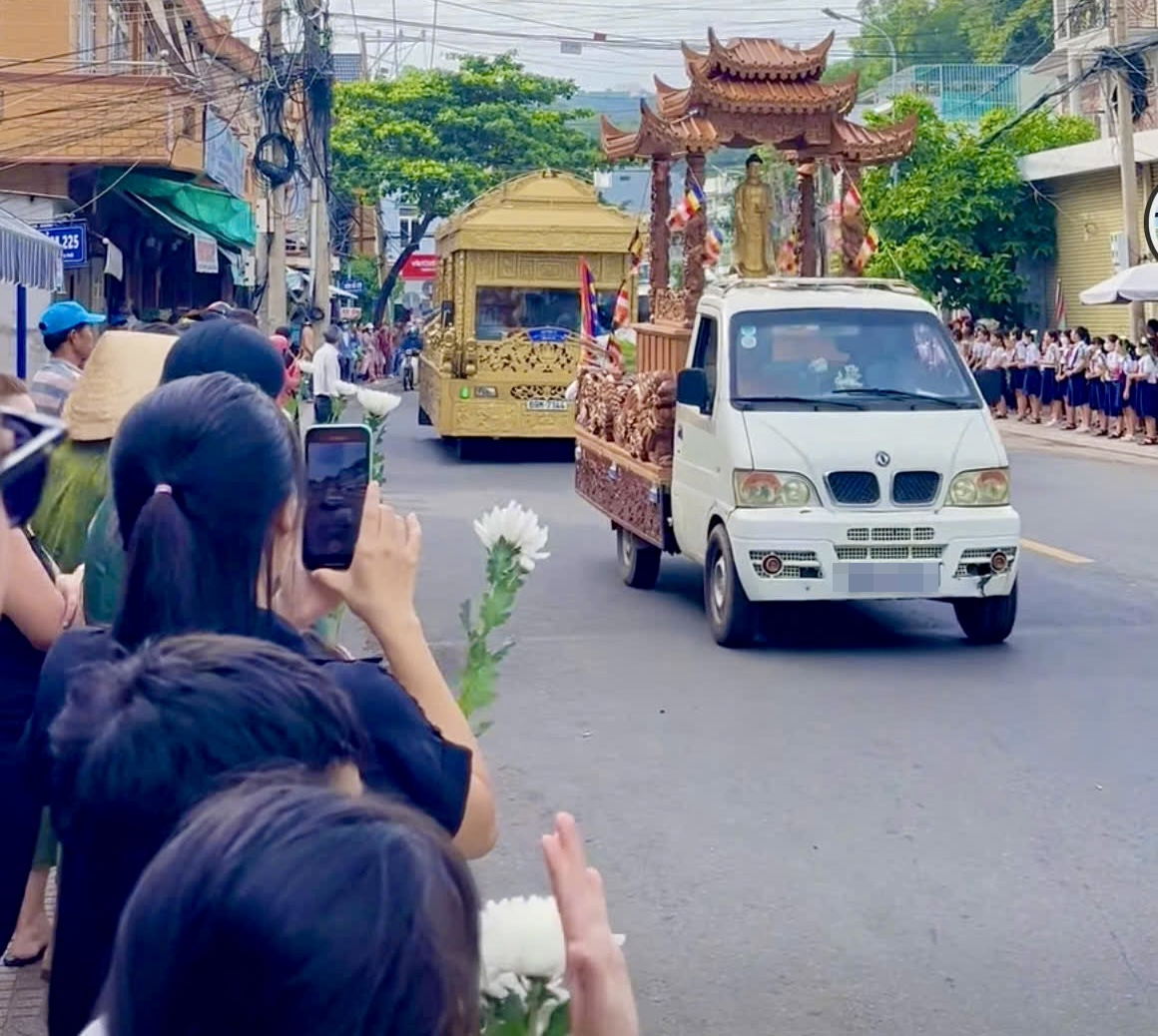 Xe tang đưa linh cữu hai em qua trường học, các học sinh đứng hai bên đường gửi lời chào tiễn biệt các bạn (Ảnh: Báo Người lao động)