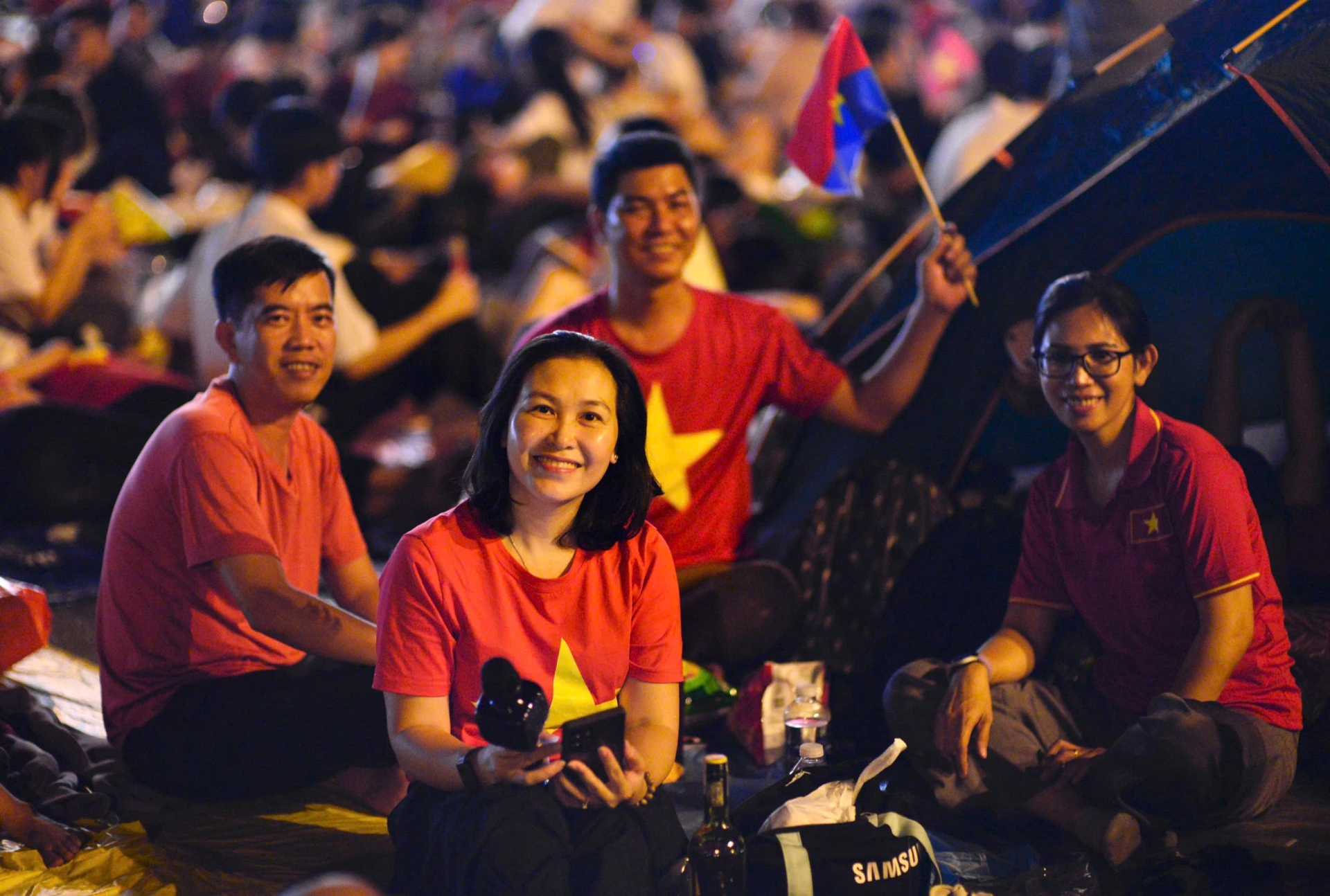 Một gia đình ngồi trước chiếc lều mang theo, ai cũng vui vẻ trò chuyện rôm rả dù đã 1 giờ sáng Ảnh: Phan Diệp