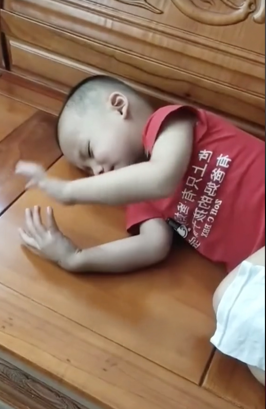 Dù đang ngủ nhưng câu bé vẫn giơ tay lướt điện thoại khiến bố mẹ hoang mang.