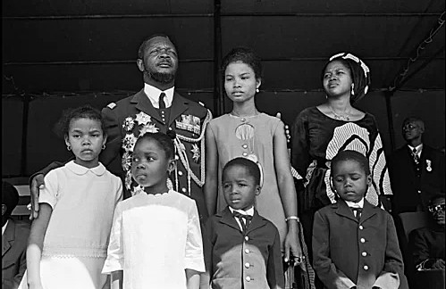 Vua Bokassa và cô con gái giả đứng cạnh nhau trong buổi nhận con