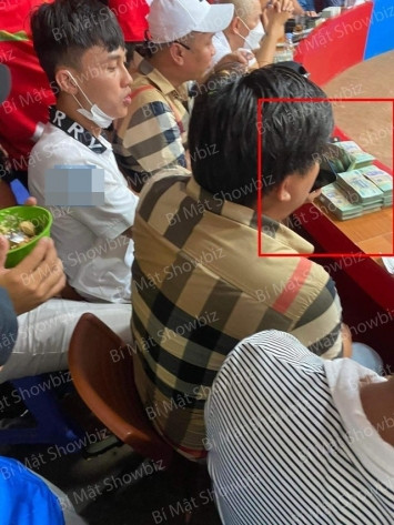 Phan Công Khanh ngồi chơi bài trong Casino, trước mặt là nhiều cọc tiền 500.000 đồng.