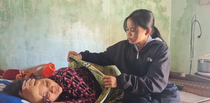 Bà Phạm Thị Lan (40 tuổi, mẹ Ca) đang nằm co ro vì chứng bệnh lạ khiến bà không thể ngồi dậy trong 4 năm qua.