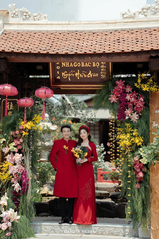 Cô dâu chú rể chụp ảnh trước khuôn viên nhà gỗ Bắc Bộ vô cùng ấn tượng với bày trí 100% hoa tươi