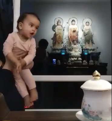 Cô bé nói bập bẹ nhưng tỏ ra rất hào hứng khi được mẹ dạy niệm Phật.