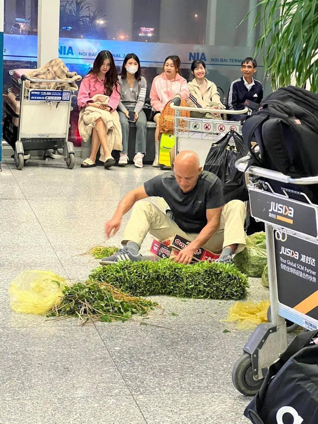 Xuất hiện hình ảnh người đàn ông ngồi nhặt rau muống ngay giữa sân bay, 'quà' Việt được du khách mê mẩn? - ảnh 1