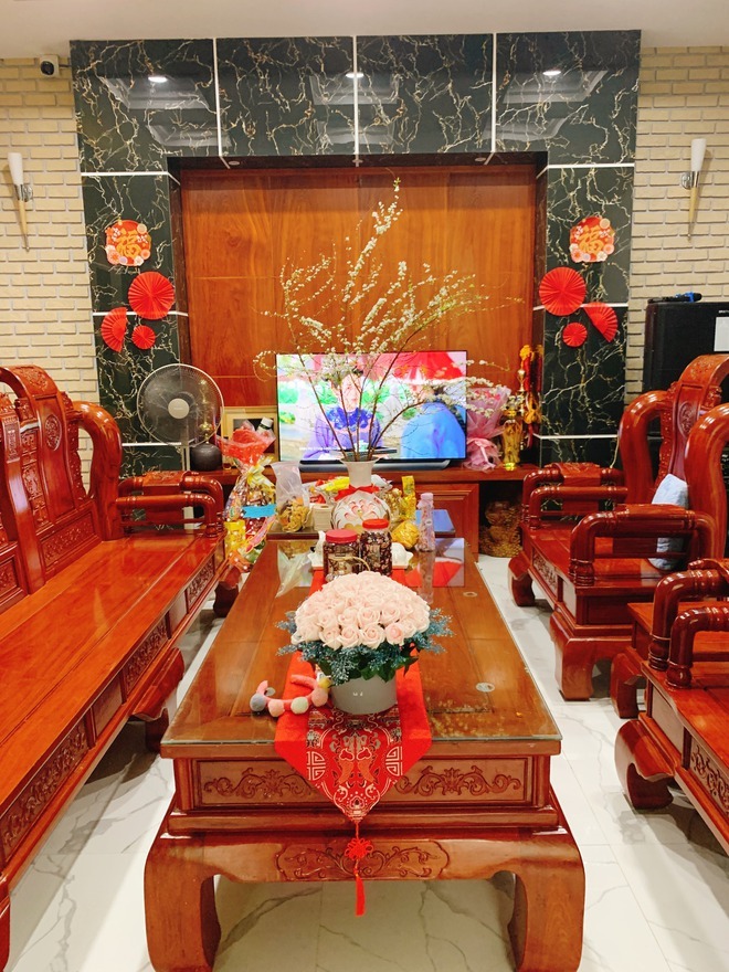 Phòng khách nổi bật với bộ bàn ghế gỗ lớn cùng nhiều họa tiết trang trí dịp Tết vô cùng ấm cúng