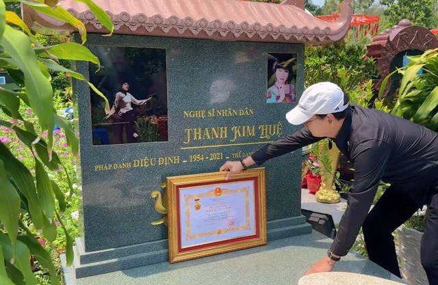Nghệ sĩ Thanh Điền cầm bằng khen đến thăm mộ vợ