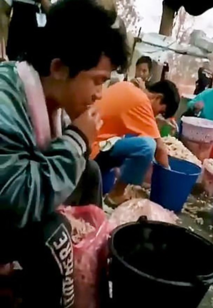 Công nhân dùng miệng rút xương chân gà tại một cơ sở sản xuất ở Thái Lan