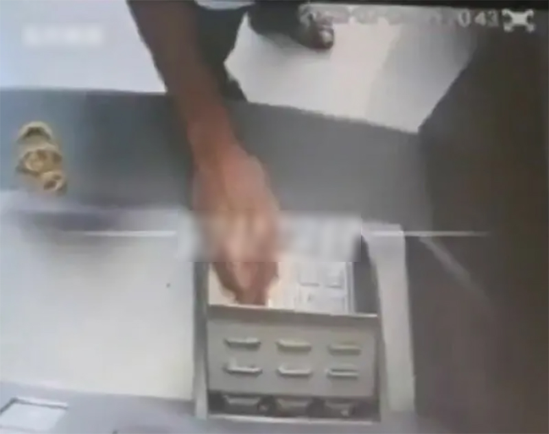 Hình ảnh được camera ghi lại khi người đàn ông nhét tiền vào máy ATM