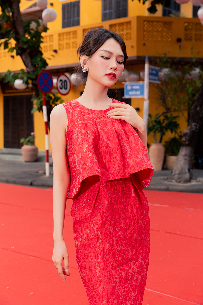 Hoa hậu Mai Phương nền nã diện đầm đỏ, bèo nhún nhẹ nhàng cành làm tăng phần nữ tính cho nàng hậu.