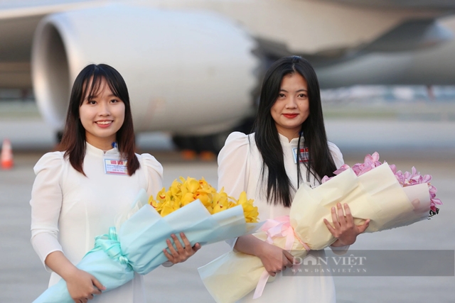 Hai nữ sinh tặng hoa cho vợ chồng Chủ tịch nước Trung Quốc trước khi họ rời Việt Nam (Ảnh: Dân Việt)
