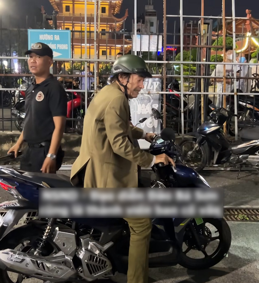 Nam diễn viên kỳ cựu Đào Bá Sơn chạy xe máy vào cổng, được bảo vệ hướng dẫn chỗ gửi xe (Ảnh: Cắt từ clip của Bestie)