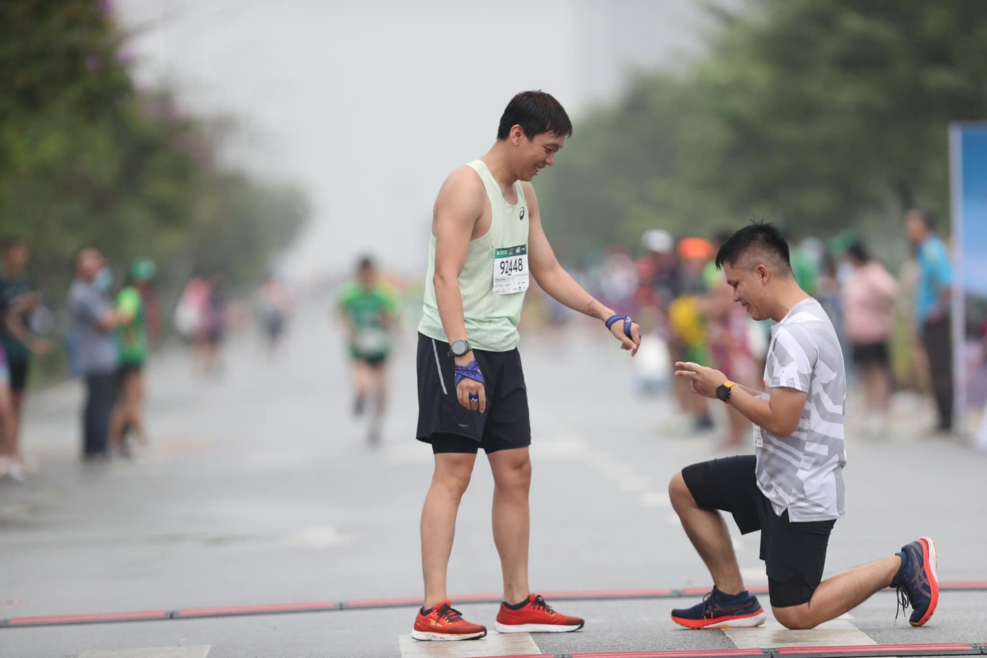 Chàng trai quỳ gối cầu hôn nửa kia khi cả hai vừa chạy đến đích (Ảnh: VnExpress Marathon)