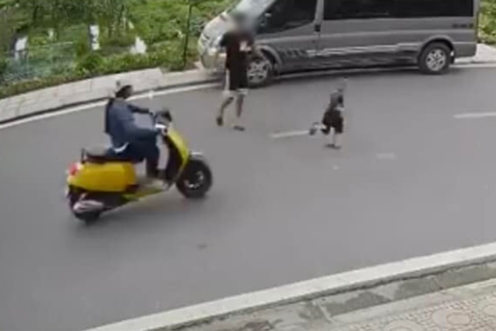 Bé trai chạy băng qua đường bị xe máy tông trúng. (Ảnh cắt từ clip).