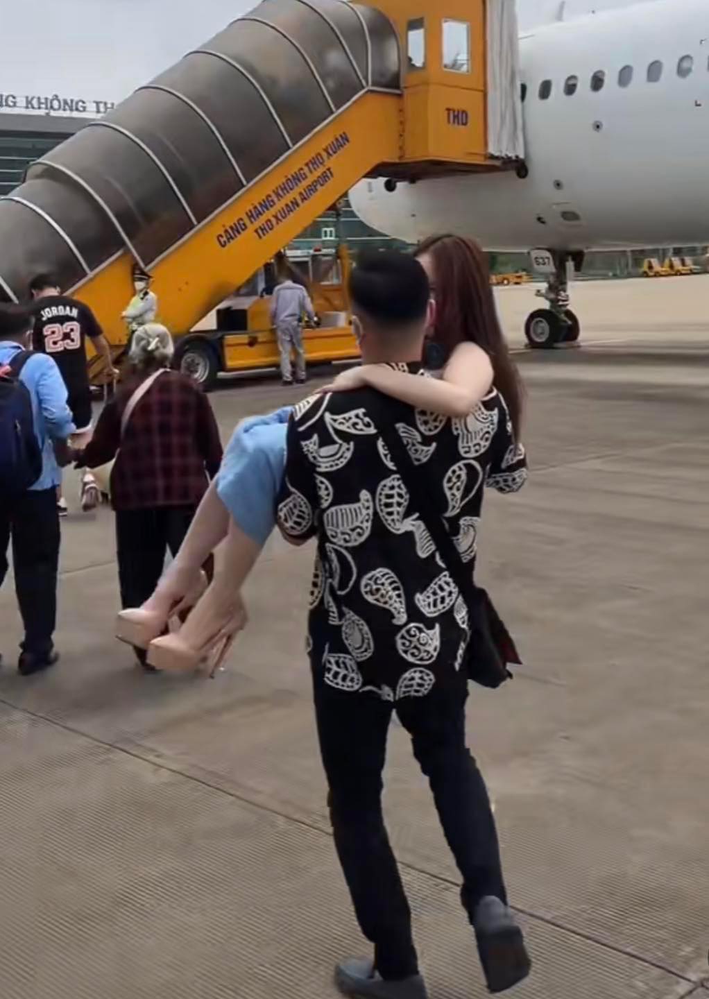 Hình ảnh anh chàng bế vợ lên máy bay gây tranh cãi.