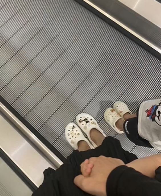 Mẹ cho trẻ đeo giày cao su khi đi thang cuốn.