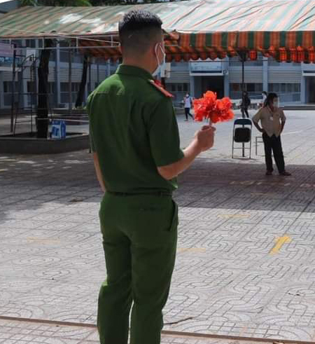 Trong lúc các thí sinh đang làm bài thi, chiến sĩ công an này tranh thủ kết một đoá hoa, sau đó đứng đợi sẵn trước sân trường...