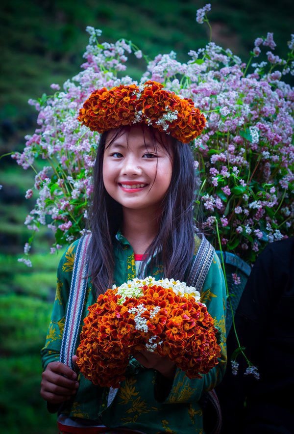 Trong hình là một cô bé bán hoa ở dốc Thẩm Mã, thuộc Hà Giang. Nụ cười rạng rỡ, nét đẹp chân phương giản dị của thiếu nữ vùng cao chinh phục hoàn toàn tất cả mọi người. (Ảnh: Minh Chiến, Hữu Linh)