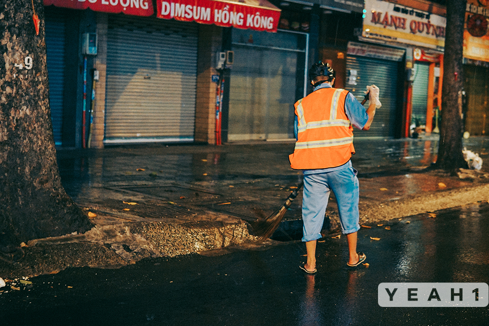 Chiều tối ngày 22/8, TP.HCM có mưa nặng hạt, một công nhân vệ sinh vẫn miệt mài làm việc trong điều kiện trời mưa.