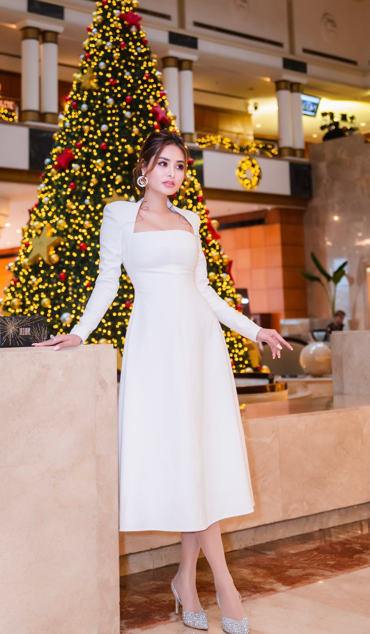 Hoa hậu Di Khả Hân nổi bật tại sự kiện khi lựa chọn trang phục đầm trắng kết hợp cùng phụ kiện dày cao gót đính đá lập lánh, điểm cộng là chiếc ví đến từ thương hiệu Dior phiên bản mùa lễ hội.