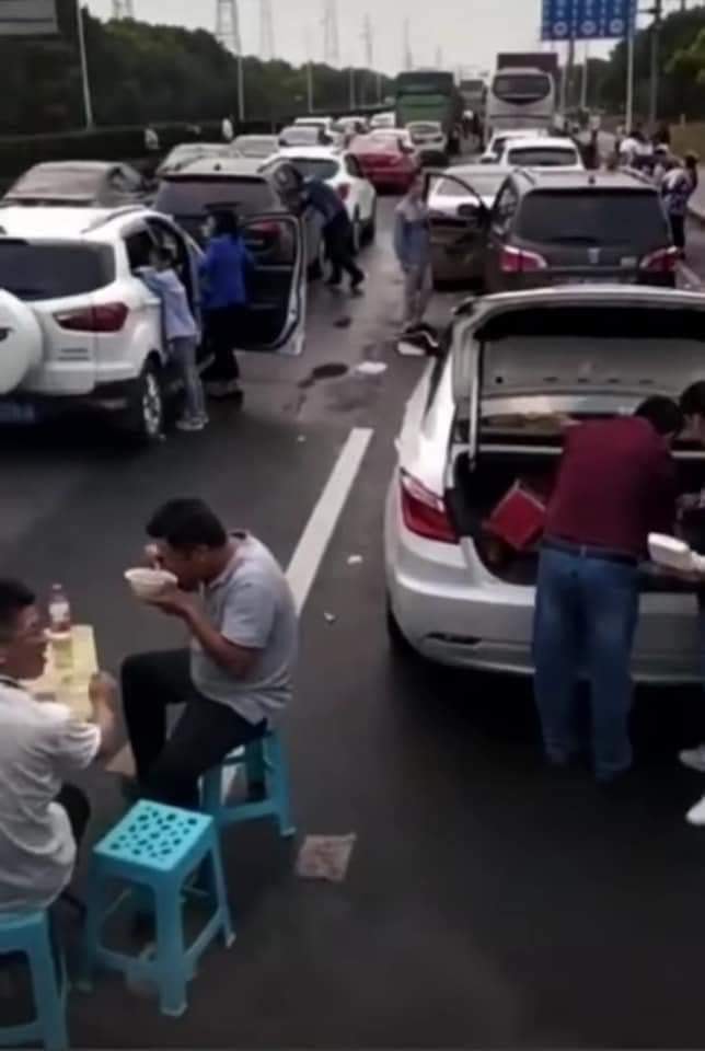Hình ảnh 2 thanh niên dọn bàn ra giữa lúc kẹt xe để ăn uống khiến CĐM xôn xao.
