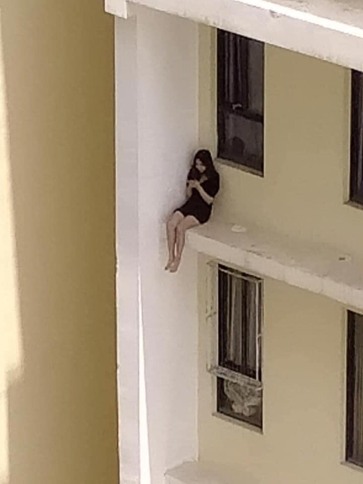 Cô gái leo ra ban công chung cư cao tầng ngồi vắt vẻo?