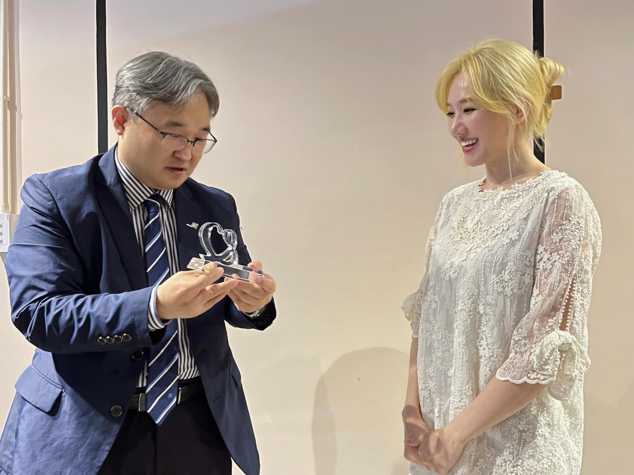 Hari Won nhận kỷ niệm chương từ đại diện quỹ GNI tại Việt Nam.
