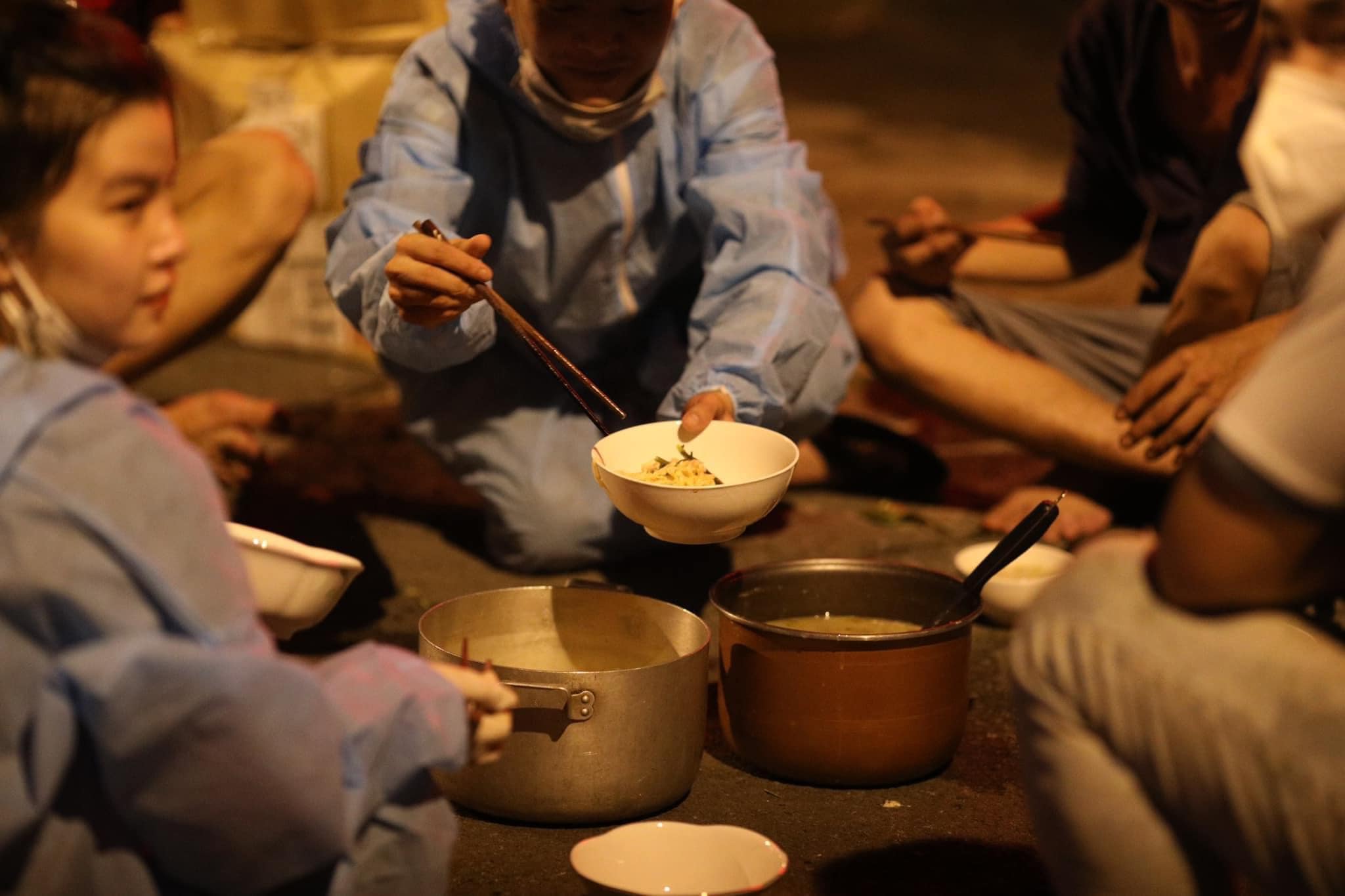 Xót xa hình ảnh bữa ăn vội trên nền đất của các tình nguyện viên chống dịch - ảnh 1