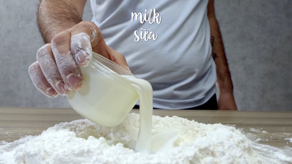 Trộn hỗn hợp bột mì đa dụng, bột mì tự nổi, đường, muối và sữa ở nhiệt độ phòng để chuẩn bị cho phần vỏ bánh. 