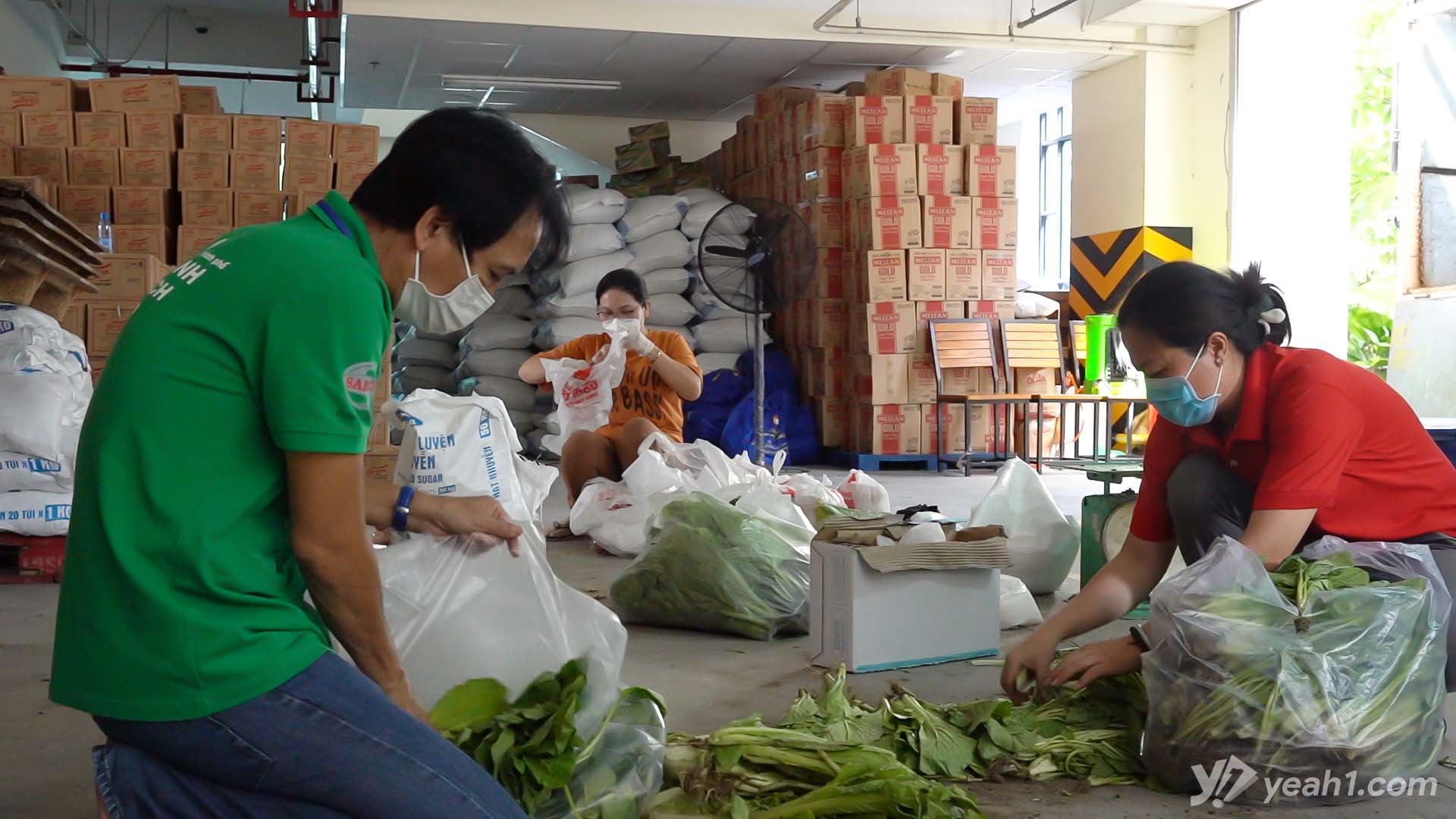 Các cán bộ, tình nguyện viên đang cẩn thận lựa chọn rau củ để chuẩn bị vận chuyển đến các khu vực cách ly, phong tỏa trên địa bàn thành phố. 
