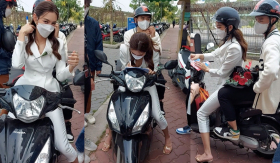 Nguyễn Thúc Thuỳ Tiên được bắt gặp đèo trợ lý đi làm bằng xe máy, vừa ngồi trên xe vừa kí tặng fan