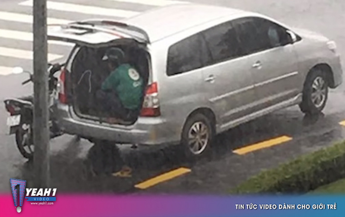 Góc đáng yêu: Bác tài ô tô mở cốp xe để anh xe ôm ngồi trú tạm giữa trời mưa to